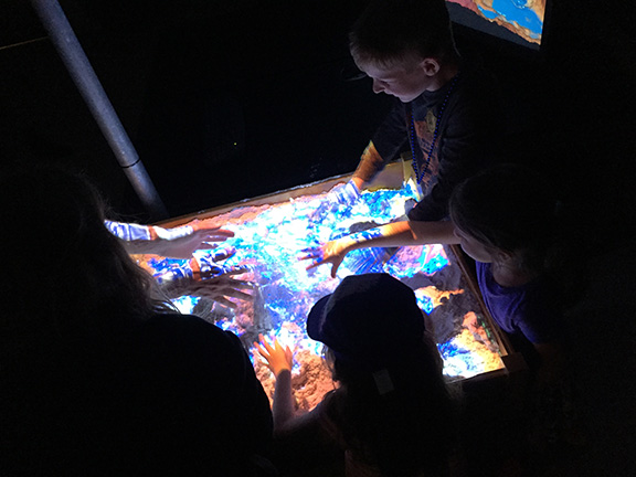 Children playing in the AR Sandbox.