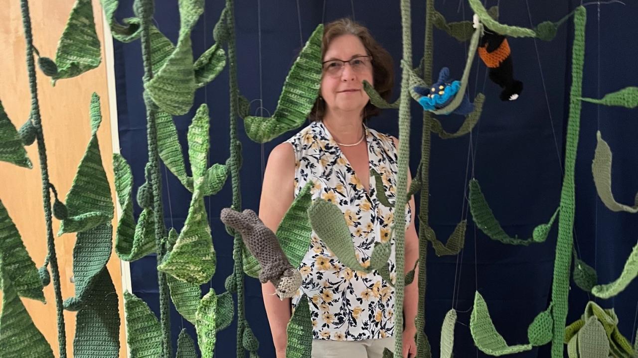 Susann Pinter stands behind display of crochet marine life