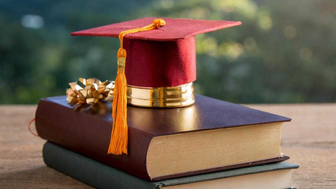 A graduation cap on top of books