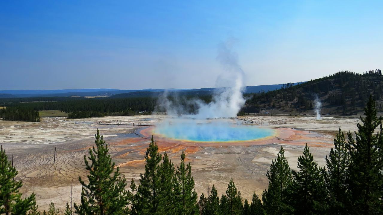 Water emitting steam in the middle of a mountainous landscape