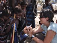 Female student showing young child in Ethiopia their photo on the camera screen.
